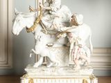 une figurine représentant une femme à cheval, avec un homme sur le dos