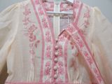 a pink and white dress hanging on a hanger