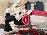 a pile of clothing that is sitting on a bed
