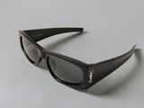 the sunglasses are made of plastic and have a black frame with a gold logo on the side