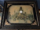 une photo représentant une horloge dans un cadre, posée sur une table