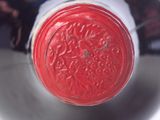 a close up view of a wine bottle with a red cap