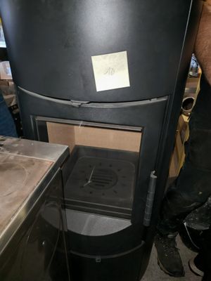 a man standing next to a black stove in a kitchen