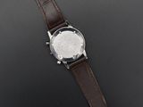 a close up of a watch on a table with a black background