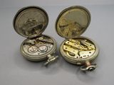 deux montres de poche en argent posées l'une à côté de l'autre sur une table