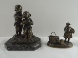 trois figurines d'enfants en bronze et un panier posés sur un socle en marbre
