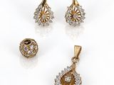 trois bijoux en or et diamants posés sur un fond blanc