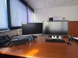 a desk with two monitors and a phone on it