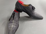 a pair of gray shoes with red laces on them