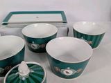 five cups and a saucer sitting on a table
