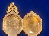 a gold locke with a picture inside of it on a blue surface