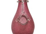 un vase rose posé sur une surface blanche