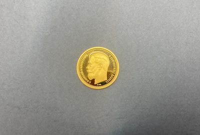gros plan d'une pièce d'or sur laquelle figure un homme