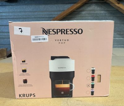 une boîte posée sur une table, sur laquelle se trouve une cafetière