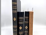 trois livres sont empilés sur une surface blanche
