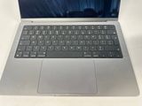 a silver laptop with a black keyboard on a white table