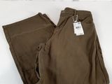 un pantalon marron posé sur une surface blanche