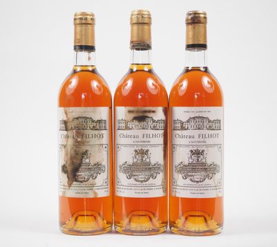 trois bouteilles de vin posées les unes à côté des autres sur une surface blanche