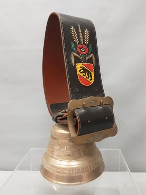 clochette en laiton avec une ceinture en cuir ornée d'une rose rouge