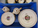 de nombreuses assiettes et tasses dans un panier posé sur la table