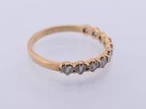 a close up of a gold ring with grey diamonds on a white background