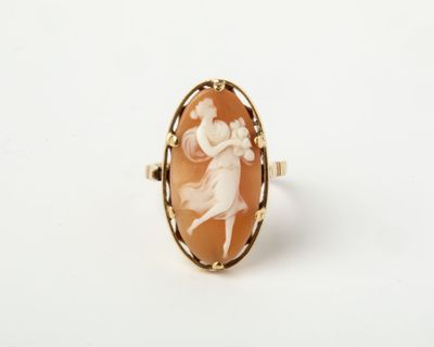 un gros plan sur une bague ornée de l'image d'une femme en robe