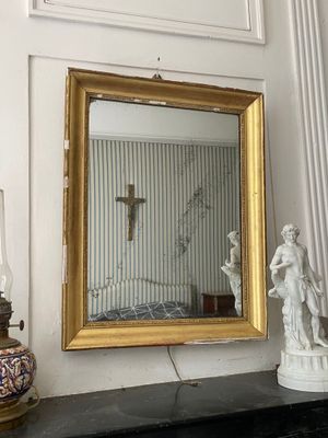 un miroir et une statue posés sur la cheminée d'une pièce