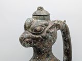 a small vase with a handle that has a face on it
