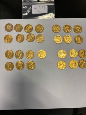 une personne tenant un morceau de papier sur lequel sont représentées des pièces d'or