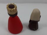 two figurines of a woman and a man on a white surface