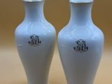 two white vases sitting on a table next to each other