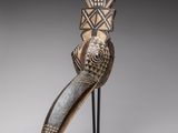 une sculpture en bois représentant un oiseau au long bec, posée sur un socle