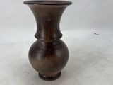 a brown vase that is sitting on a white surface