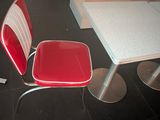 a red chair and a white table in a room