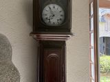 a grandfather clock on the wall next to a window