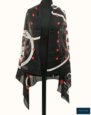 une écharpe noire et blanche à pois rouges, posée sur un mannequin