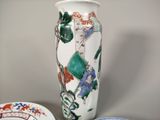 a vase with a painting on it next to a plate with a bowl