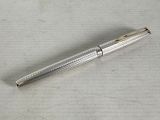 a silver pen sitting on top of a piece of paper