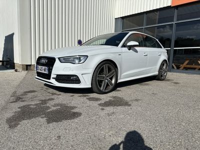 une Audi blanche garée devant un immeuble