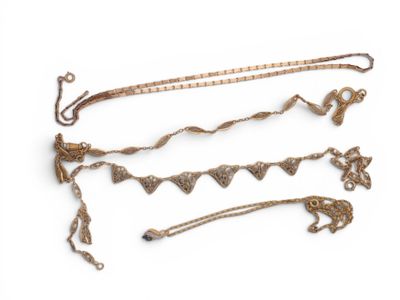 several pieces of gold jewelry are displayed on a white surface