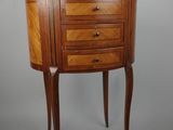 a small wooden table with three drawers and a drawer underneath it