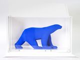 a blue polar bear in a clear box on a white surface