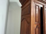 a tall wooden cabinet in the corner of a room