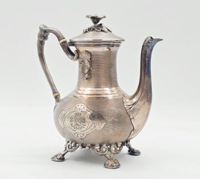 une théière ancienne en argent ornée d'un oiseau sur le couvercle