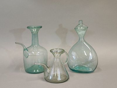 trois vases en verre posés l'un à côté de l'autre sur une table