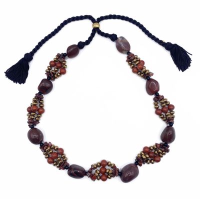un collier orné de perles et de pompons sur fond blanc