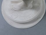 a white figurine of a foot on a plate