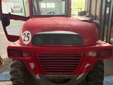 a red tractor parked inside of a building with a number on the front