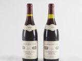 two bottles of wine sitting next to each other on a white surface