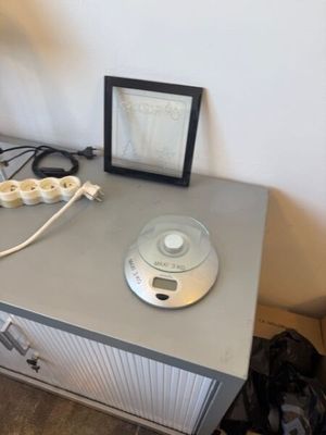 un bureau sur lequel se trouvent une lampe, un cadre photo et une photo